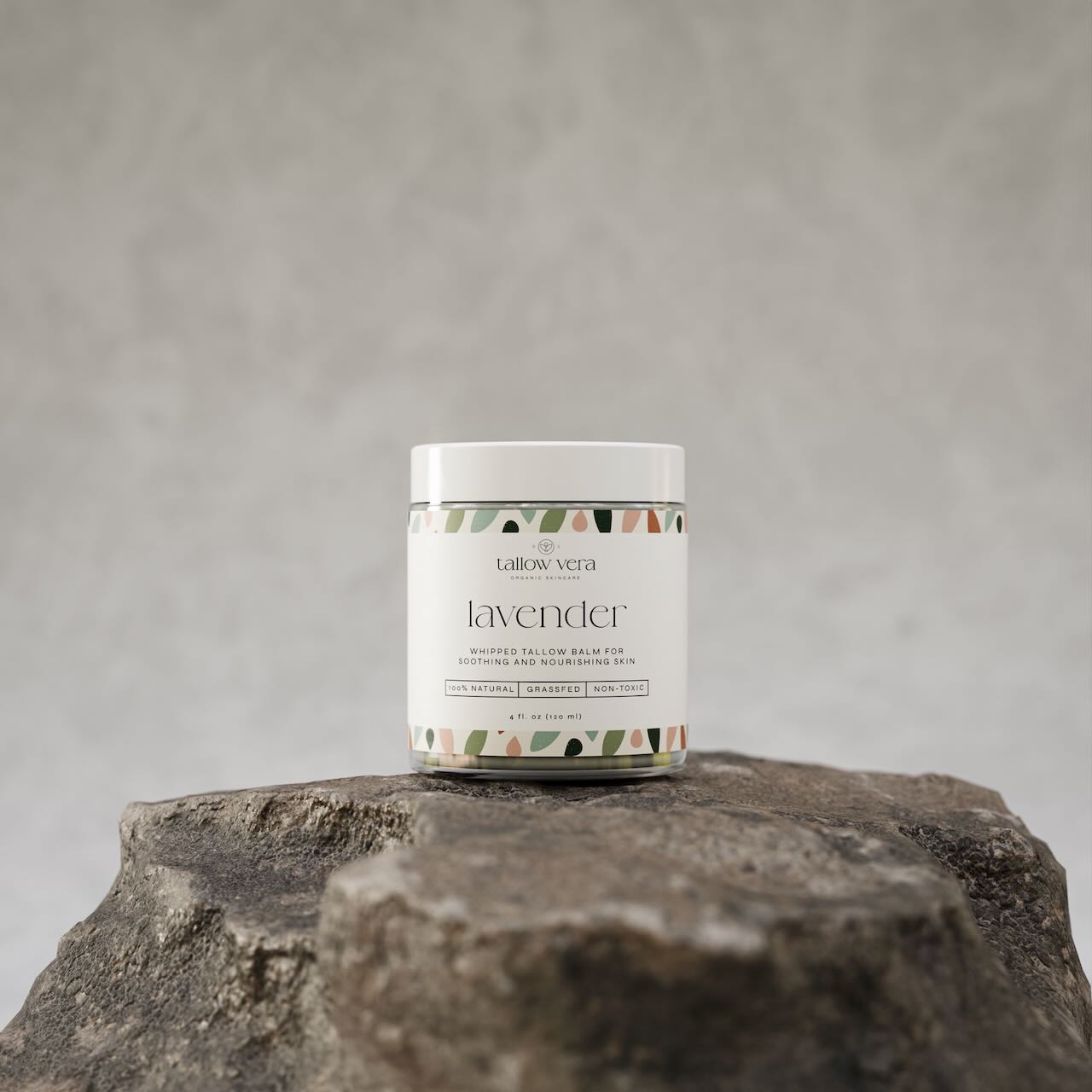 4oz lavender whipped tallow moisturizer resting on a rock