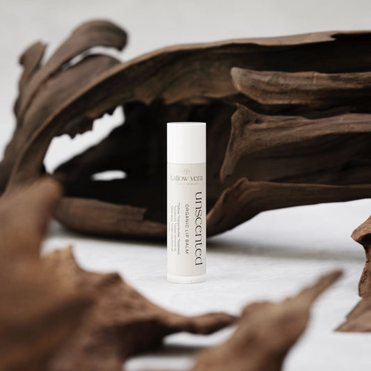 Tallow Vera's organic unscented tallow lip balm in front of wood piece decor
