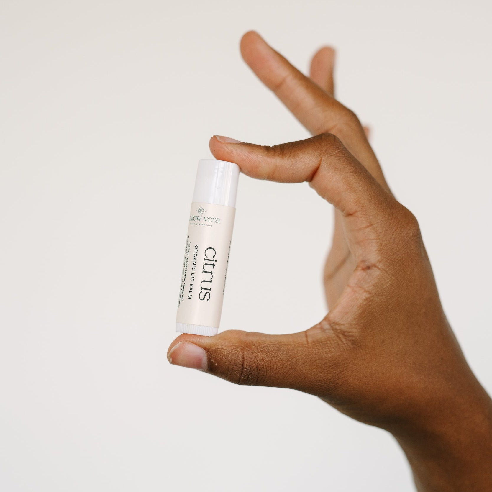 Hand holding Tallow Vera's organic citrus tallow lip balm