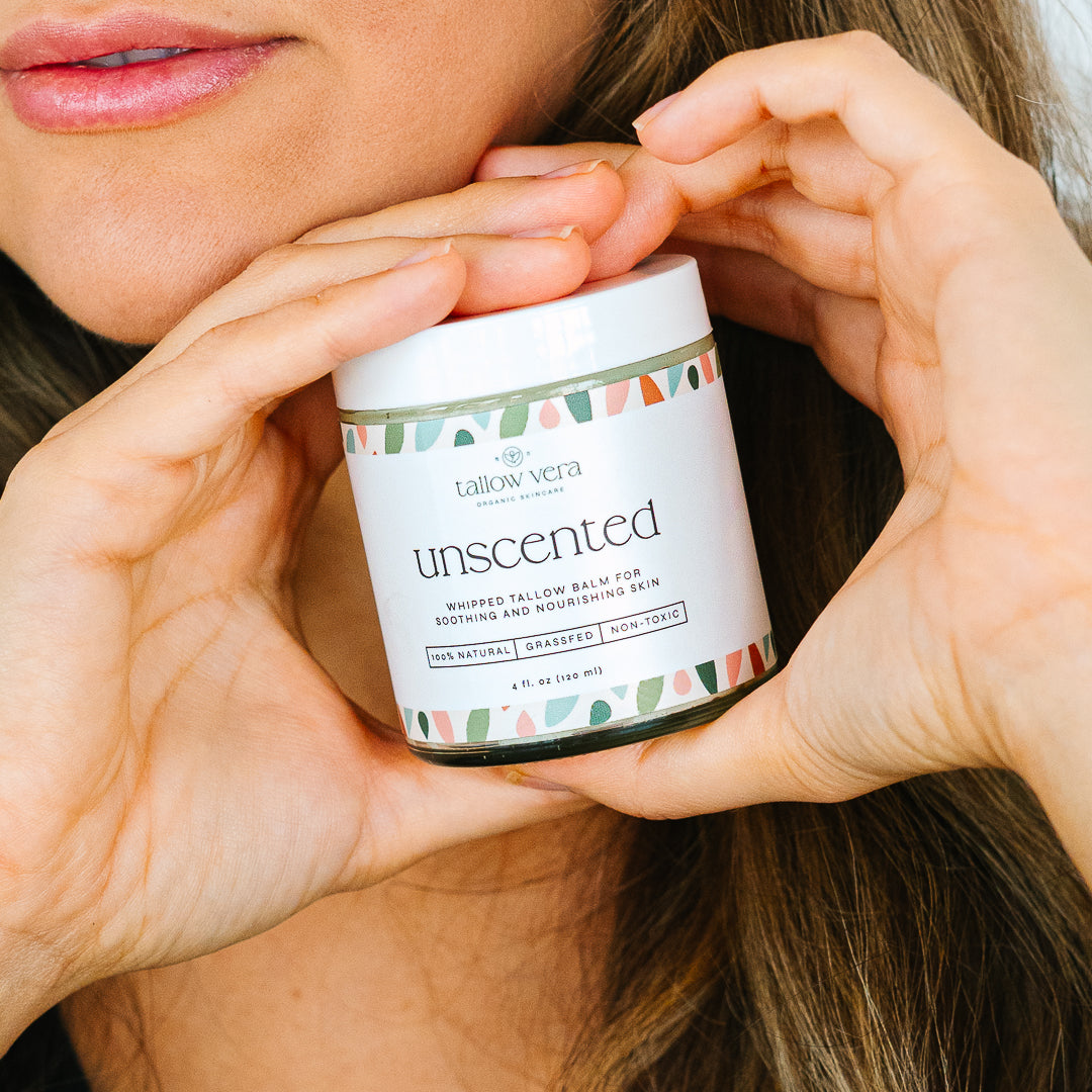 Woman holding Tallow Vera's 4oz tallow balm by her face