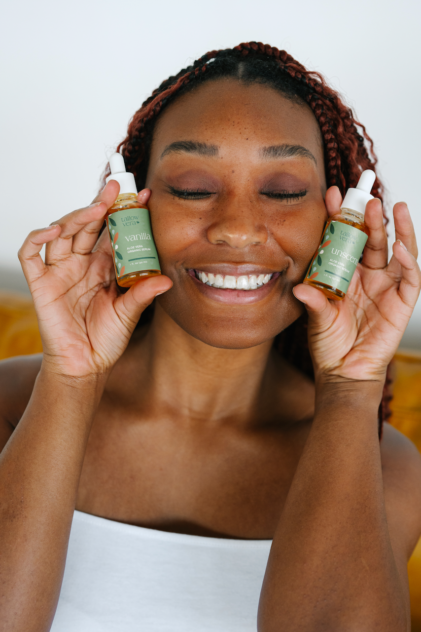 Woman holding two bottles of skincare product in front of her face