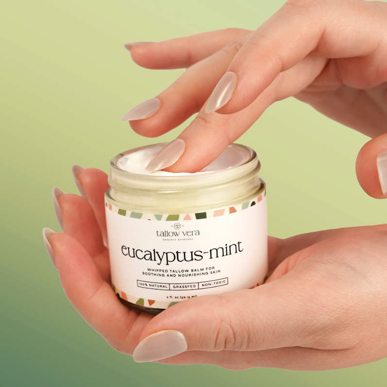 Hand holding a jar of eucalyptus-mint cream against a green gradient background